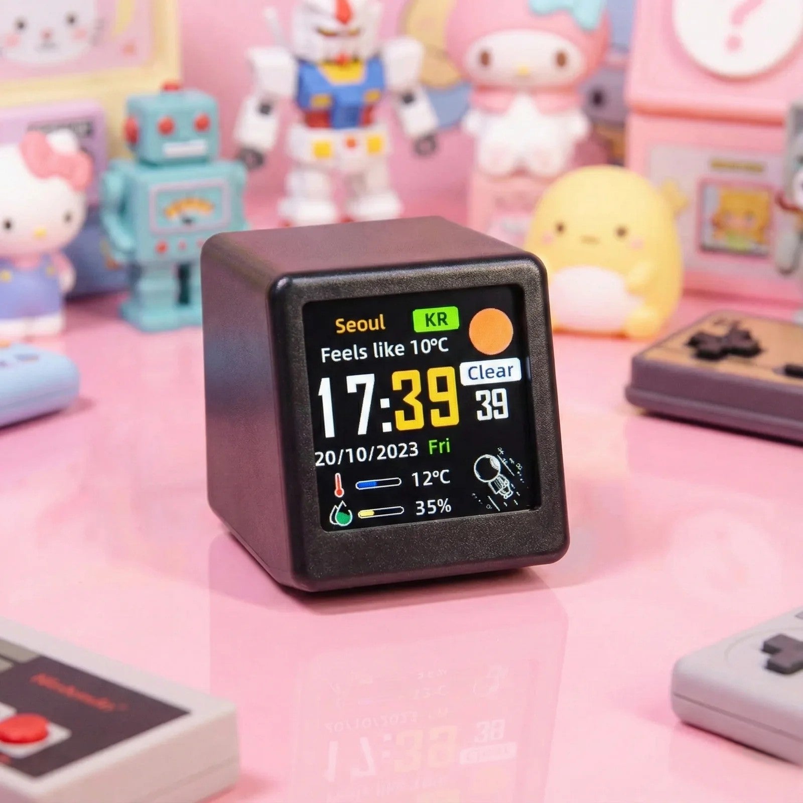 Digital clock with weather display on a pink surface with toys in the background