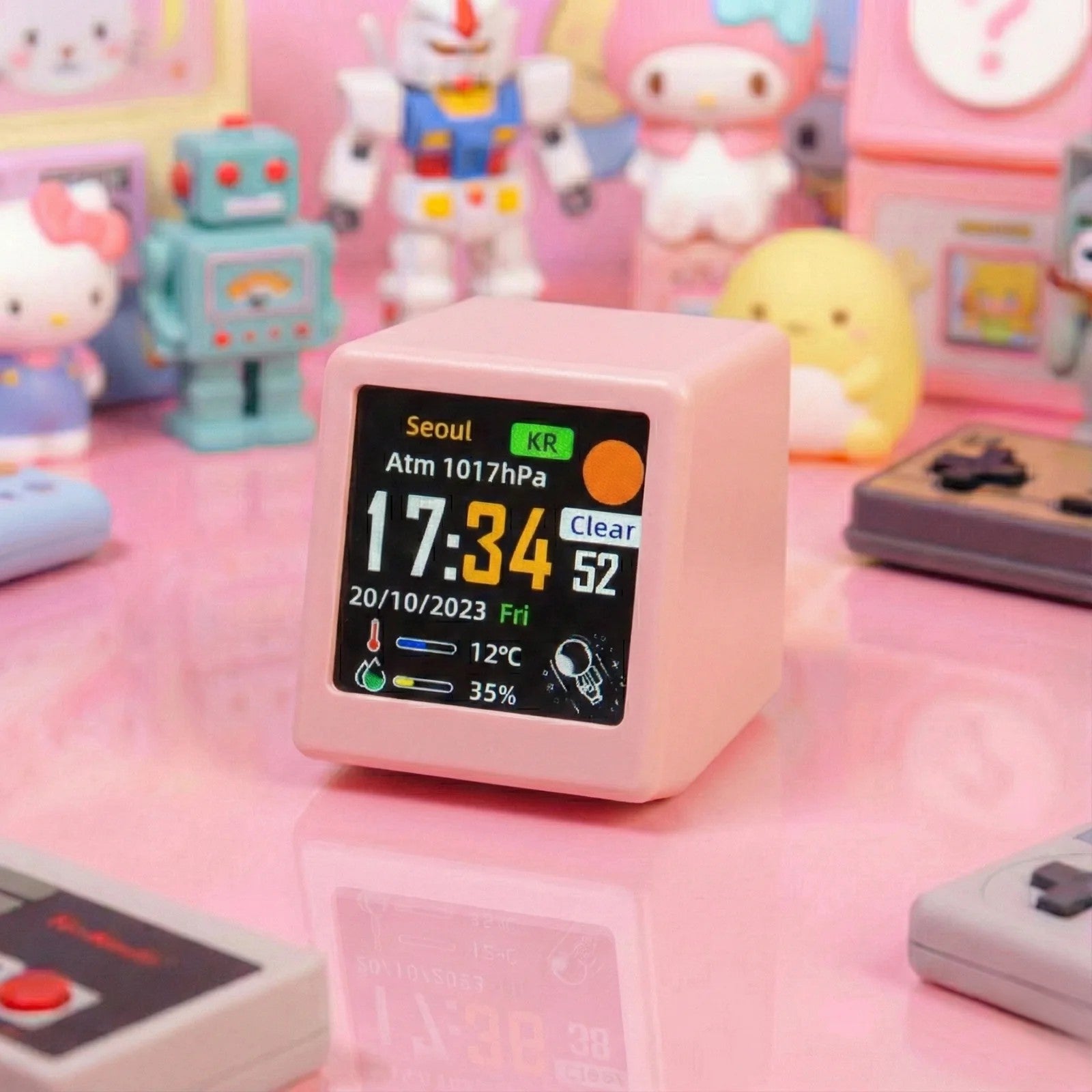Pink digital clock with weather display on a pink surface with toys in the background