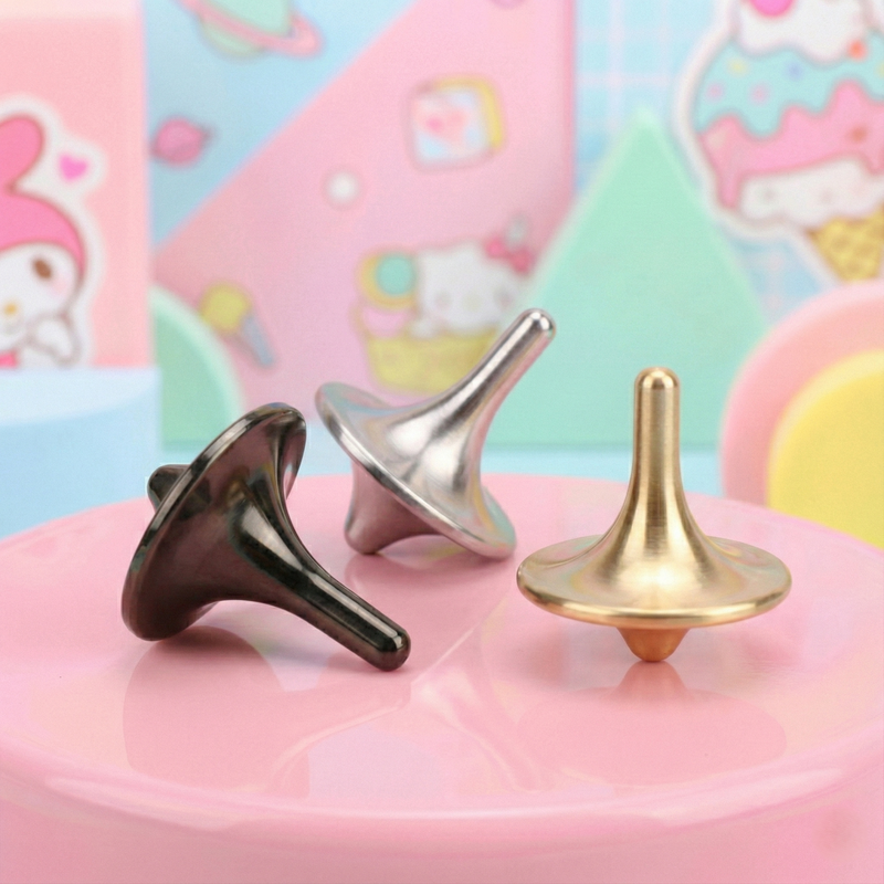 Three metallic spindles in black, silver, and gold on a pink surface with a colorful, cartoon-like background.