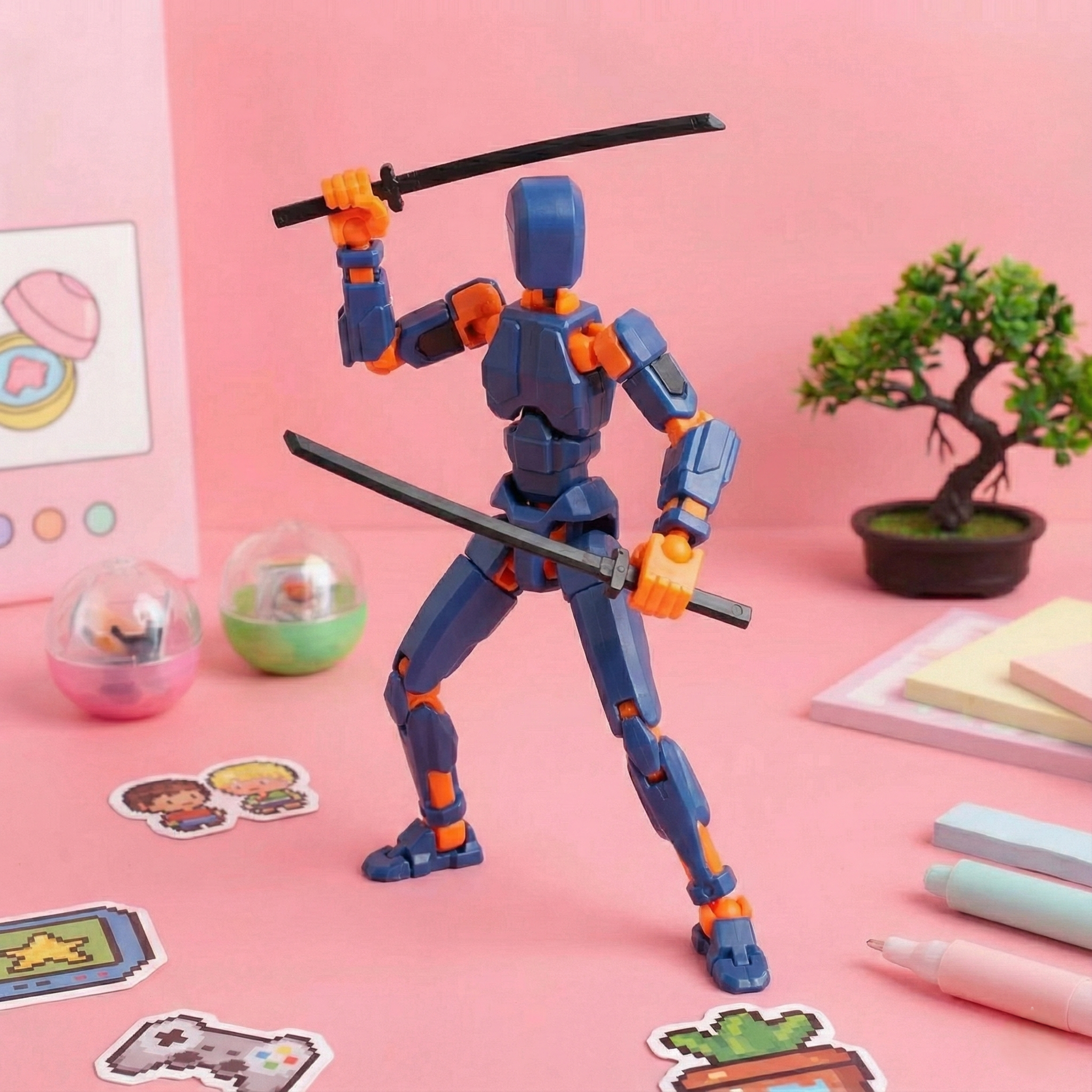 Action figure with blue and orange design holding two swords on a pink background with stationery items.